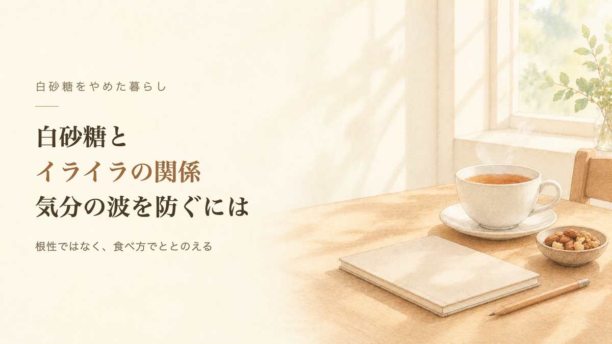 窓辺の木のテーブルに、湯気の立つ紅茶とナッツの小皿、ノート